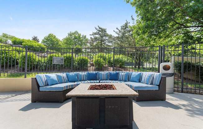 A patio with a sofa and a table with a plaque on the fence.