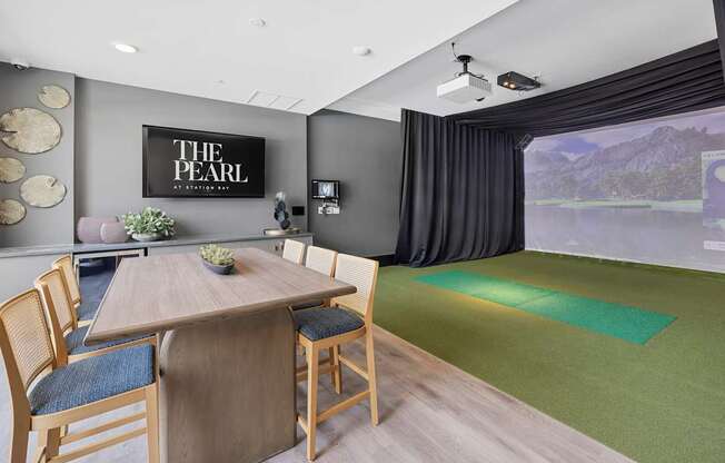 A conference room with a table and chairs and a screen on the wall.