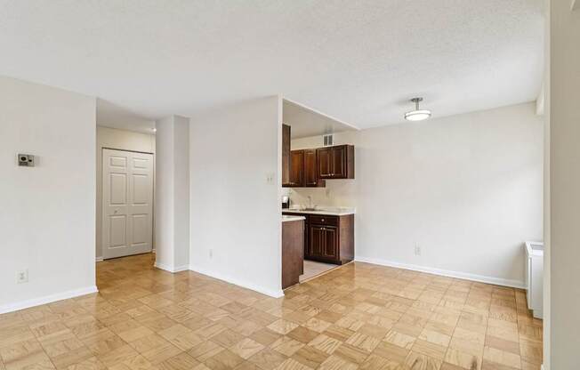 A kitchen area with wooden flooring and white walls.