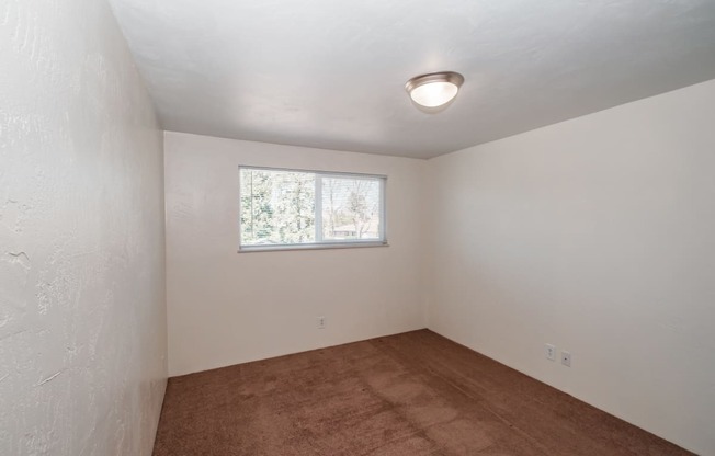 a small room with white walls and a small window