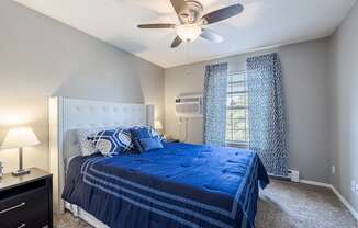 the master bedroom has a large bed and a ceiling fan