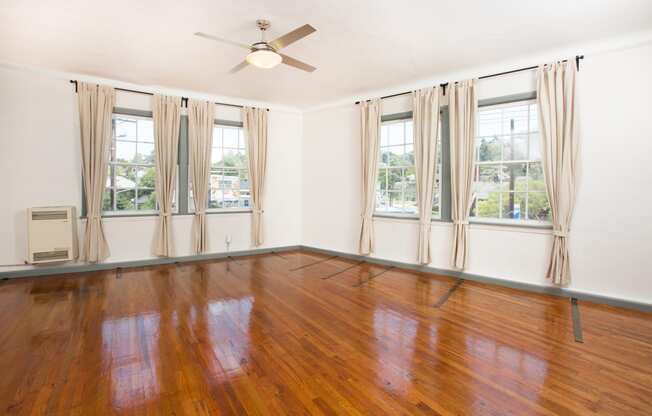 an empty living room with wood floors and a ceiling fan at Del Mor, Los Angeles, CA