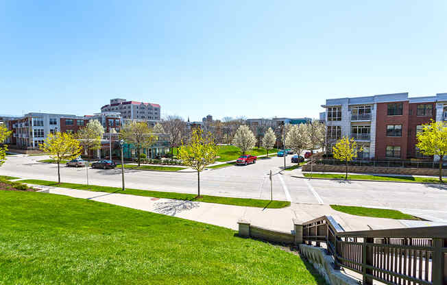 a view of a parking lot with green grass and buildings