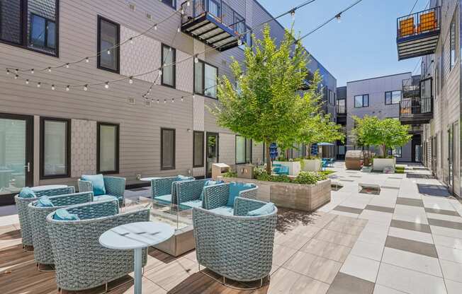 a patio with blue chairs and tables and a building in the background