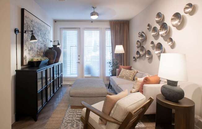 a living room with a couch and chairs and plates on the wall