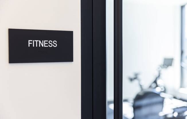 a fitness gym sign on a wall next to a mirror at Analog PDX Apartments, Portland