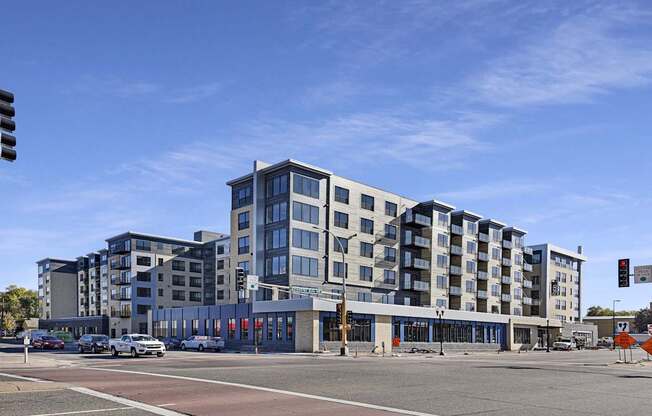 A modern multi-story building with a parking lot in front.