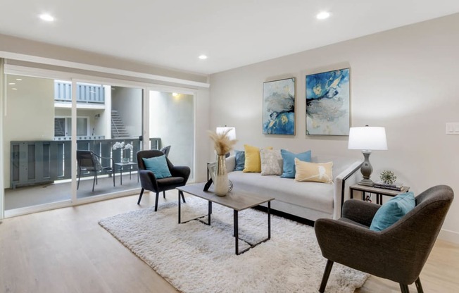 a living room with a couch and chairs in front of a window