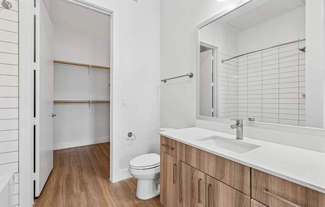 A white bathroom with a toilet, sink, and medicine cabinet.
