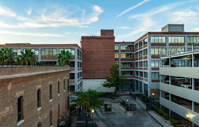 A view of a courtyard between two buildings with a brick chimney in the middle.