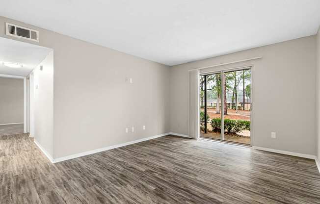 A room with a sliding glass door leading to a backyard.