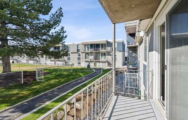 A view of a balcony with a railing and a building in the background.