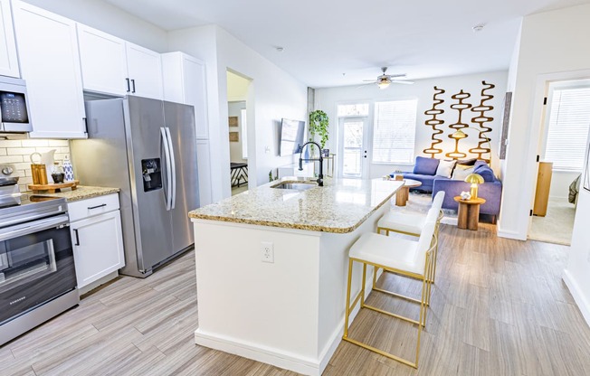 a kitchen with stainless steel appliances and an island with two stools
