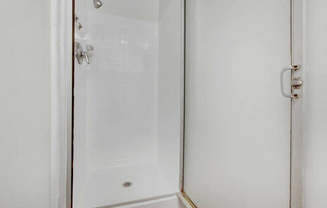 a white shower with a glass door in a bathroom