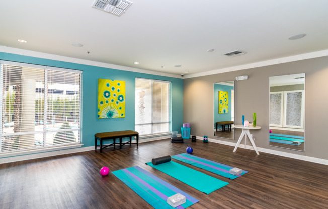 Yoga studio with mirrors, equipment, and large windows