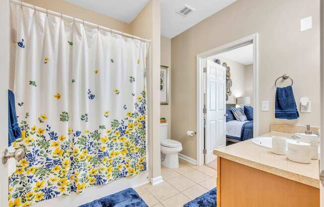 a bathroom with a shower curtain and a sink and a toilet