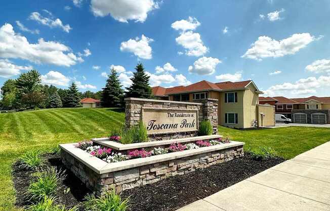 A sign that says "The Residences at Fosseana Park" is in front of a building.