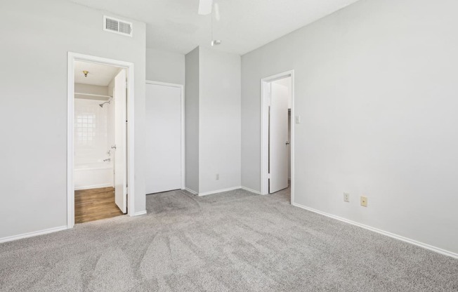 First bedroom at B1 floor plan with walk-in closet and in-room door to bathroom at Jefferson Creek Apartments in Irving, TX.