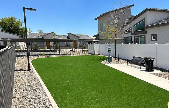 a backyard with a green lawn and a fence