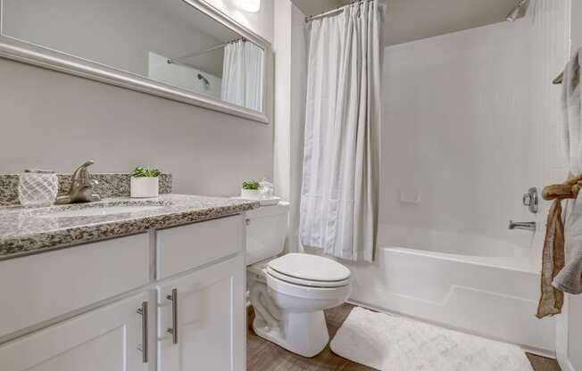a bathroom with white cabinets and a white bathtub