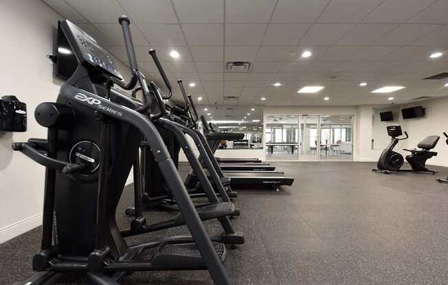 A gym with treadmills and elliptical machines.