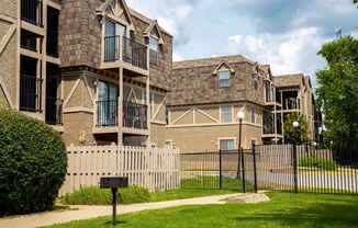 A row of houses with a black fence in front.