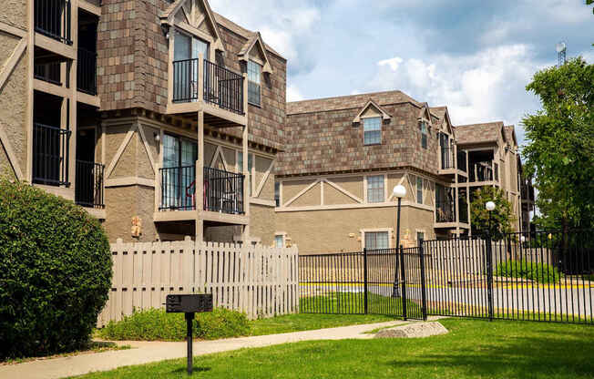 A row of houses with a black fence in front.