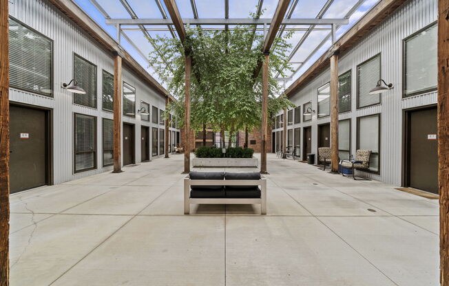 a courtyard with a bench and trees in the middle of it