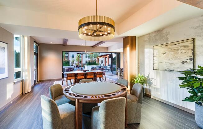 The resident game lounge features a dedicated poker table, comfortable seating, designer finishes, and seamless access to outdoor amenity spaces for socializing and entertaining.