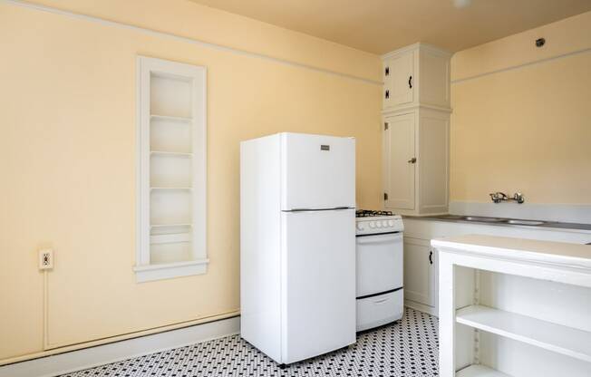 a kitchen with a white refrigerator freezer next to a stove top oven