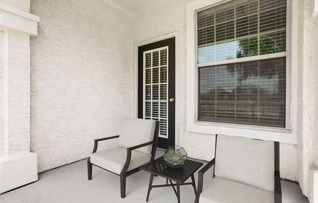 A chair and a table are placed on a patio.