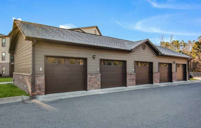 a garage with three garage doors in front of a house