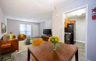 A living room with a brown table and yellow chairs.