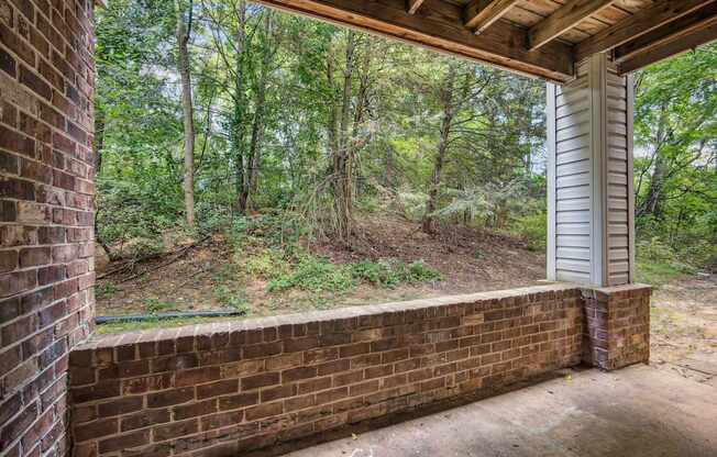 A view from a porch looking out to a wooded area.