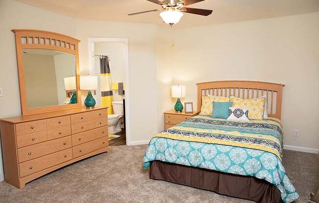 A bedroom with a bed, dresser, and mirror.