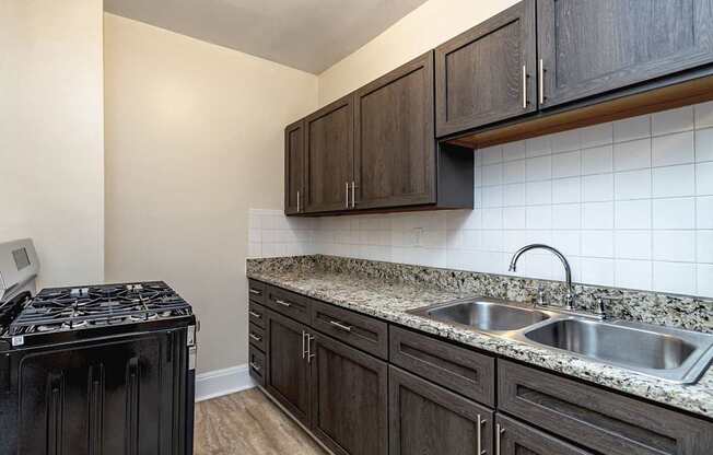 Mapleview Phase 2 renovated kitchen with espresso cabinets and dark marble countertops.