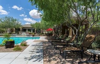 a pool with chairs and trees next to it at Canyon Crossroads in Phoenix, AZ 85085