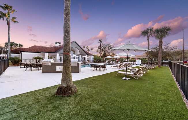 a resort style pool with lounge chairs and umbrellas