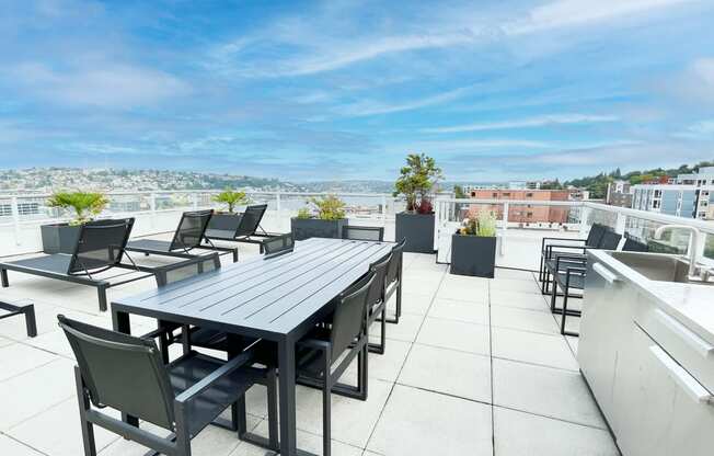 a patio with a table and chairs on a roof  at Oslo, Seattle, WA, 98102