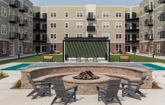 A fire pit surrounded by chairs in a courtyard.