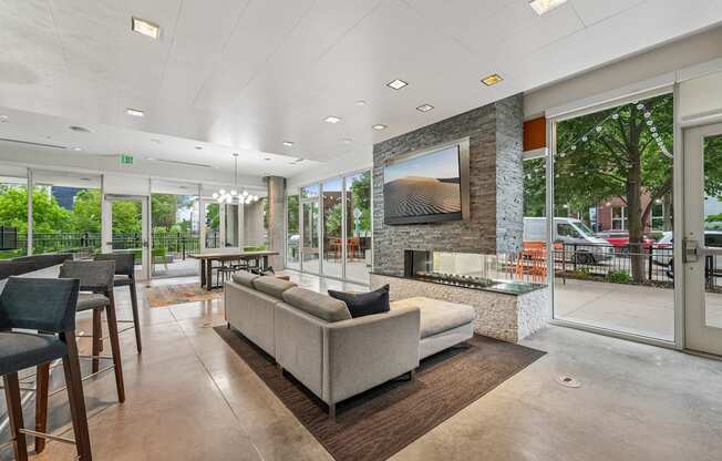 A modern living room with a large couch and a stone fireplace.