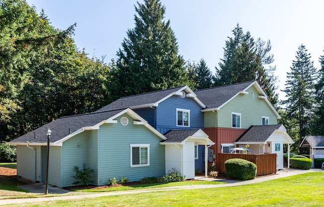 a blue house and a red and blue house with a yard and trees at Woodcreek, Poulsbo, WA