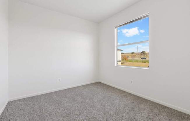 Affordable Apartments for Rent in Austin, TX 78724 – Huntington Meadows – A room with a carpeted floor and a window showing an outdoor view.