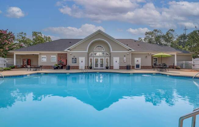 A large swimming pool in front of a house.