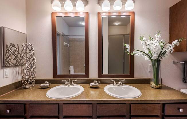 a bathroom with two sinks and two mirrors