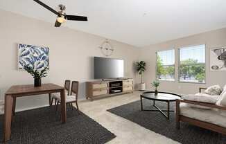 a living room with a ceiling fan and a flat screen tv