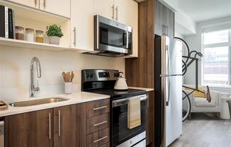 a kitchen with a sink and a refrigerator and a microwave