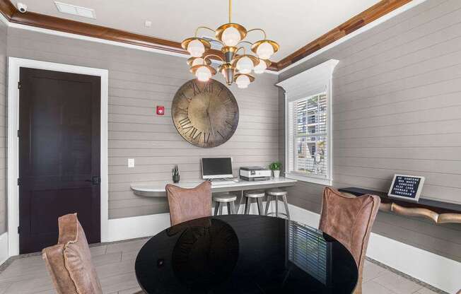 A modern dining room with a black table and chairs.