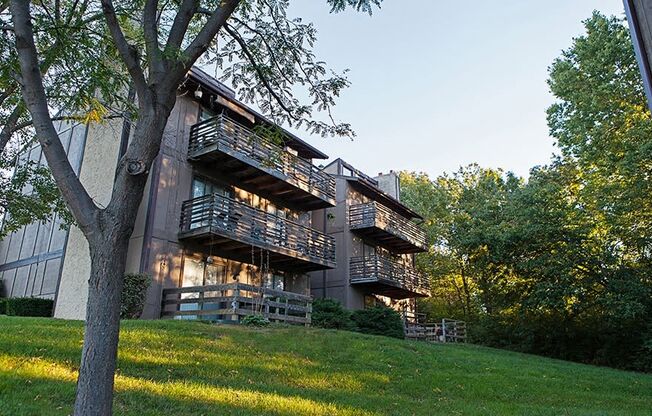 the exterior of a building with balconies on a hill