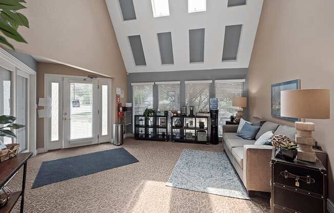 a living room with a vaulted ceiling with windows and a couch